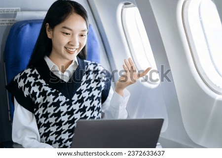 Traveling and technology. young business woman working on laptop computer while sitting in airplane.