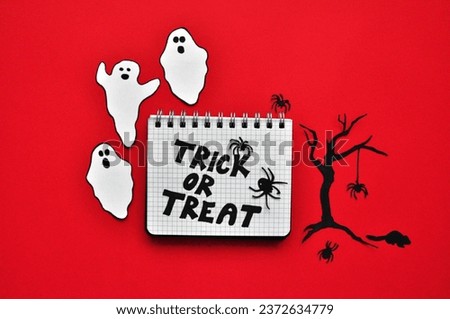 Trick or treat - red Halloween background -  ghosts next to tree with spiders 