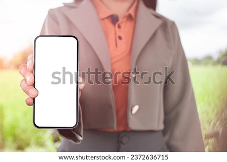 Young woman holding a smartphone with white copy space