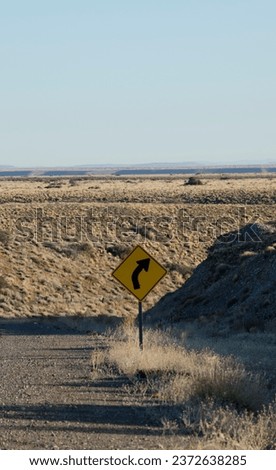 right turn sign. yellow sign on the desert route with road markings for a curve to the right