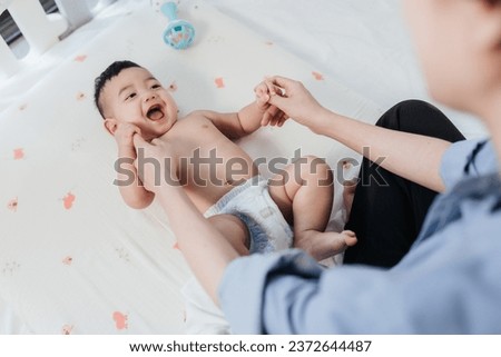 Asian Baby enjoy massage and exercises, Baby massage for stimulate development by mother. Mother makes massage for happy baby. Infant healthcare concept. Royalty-Free Stock Photo #2372644487
