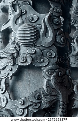 Chinese folklore carved into a stone pillar