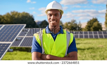 Portrait Of Smiling Male Engineer Inspecting Solar Panels In Field Generating Renewable Energy Royalty-Free Stock Photo #2372664851