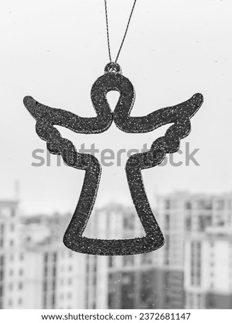 Silhouette of an angel against the background of multi-storey buildings