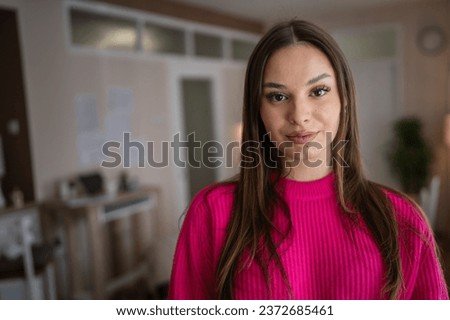 Front view portrait of one caucasian woman young female stand in her apartment at home wear sweater happy confident real people copy space