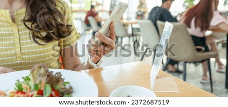 Woman use smartphone to scan QR code to pay in cafe restaurant with a digital payment without cash. Choose menu and order accumulate discount. E wallet, technology, pay online, credit card, bank app.