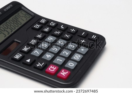 Standard black calculator, double power, uses batteries and solar panels. Isolated white.