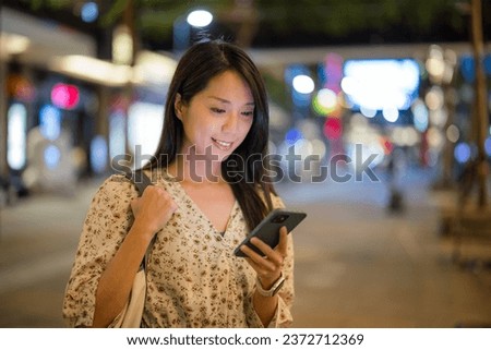 Woman use mobile phone in city at night