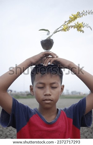 A poor asian child a drought, sorrow, sits on a dry ground, hopes and drought.