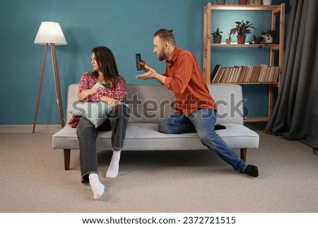 Infidelity, suspicion young couple love fight relationship, husband screaming wife cheating on phone, scolding, distrust and jealousy. Relationship Conflicts Concept. Royalty-Free Stock Photo #2372721515