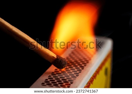 Firing point safety match. Close-up view to strike matches for matchbox. Detail of ignition matches for matchbox. Macro lighting of a match striking out a matchbox. Closeup safety match flame. Royalty-Free Stock Photo #2372741367