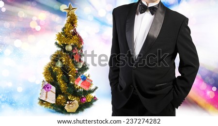 Men in tuxedo and Christmas eve tree with Gifts 