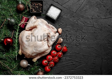 Christmas raw chicken on a background of a Christmas tree and Christmas tree decorations with copy space for your text