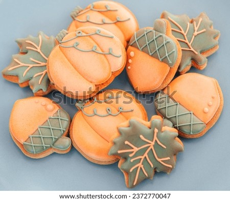 A group of gingerbread cookies on a blue background. Beautiful autumn gingerbread cookies in the form of a pumpkin, acorn, maple leaf. Autumn background cookies with icing.