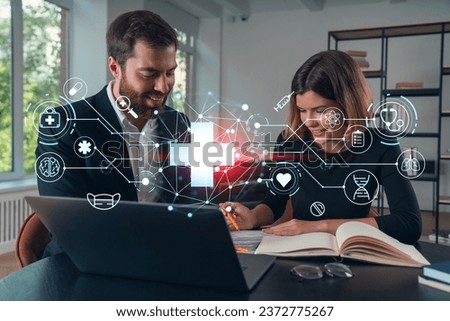 Thoughtful businesspeople typing on laptop at office workplace. Concept of team work, business education, internet surfing, brainstorm, project information technology. Medical healthcare hologram Royalty-Free Stock Photo #2372775267