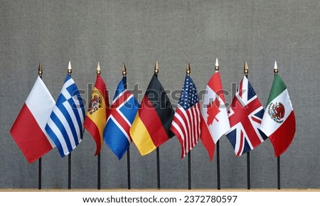 9 tabletop flags of different countries located along one line