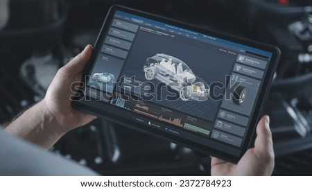 Male technician holds digital tablet computer. Simulation of real-time car diagnostics and aerodynamics testing displayed on screen. 3D animation of software with 3D virtual electric vehicle model.