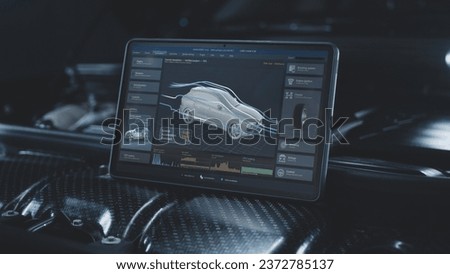 Tablet computer screen shows 3D animation of professional program for real-time car diagnostics and aerodynamics testing using 3D virtual electric vehicle model. Concept of car developing technology.