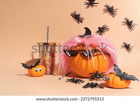 Creative pumpkin in pink wig and 8 bit sunglasses Deal with it. Retro style costume, 80s vibe style. Crawling spiders. Halloween party decoration. Copy space