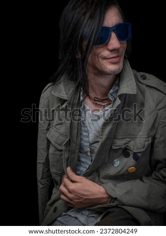 Man with dark blue sun glasses and army green old jacket
