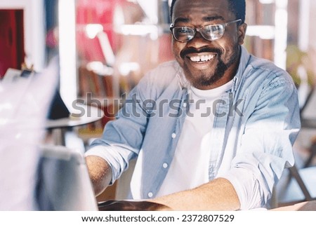 Happy ethnic man using laptop at home