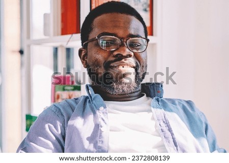 Adult ethnic man interacting with smartphone in light contemporary office