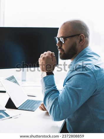 Pensive man watching laptop working in office