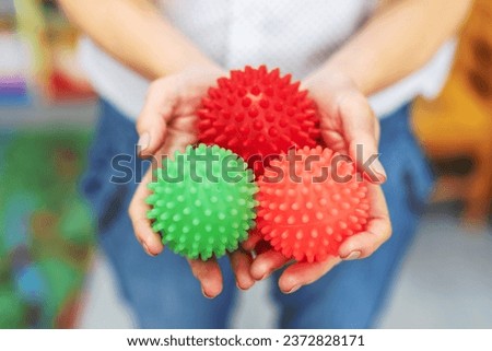 female hands holding multicolored sensory balls, stress balls for children with sensory or special needs or developmental delays. Speech therapist or psihoterapeut with massage tactile balls Royalty-Free Stock Photo #2372828171