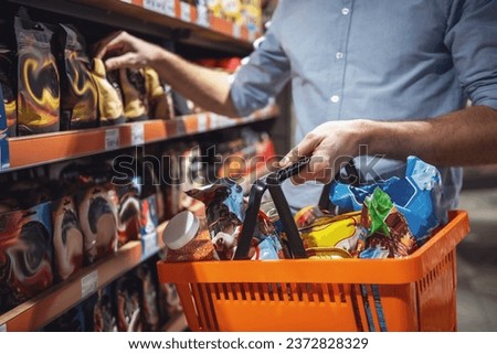 Cropped image of handsome man with a market basket doing shopping at the supermarket Royalty-Free Stock Photo #2372828329