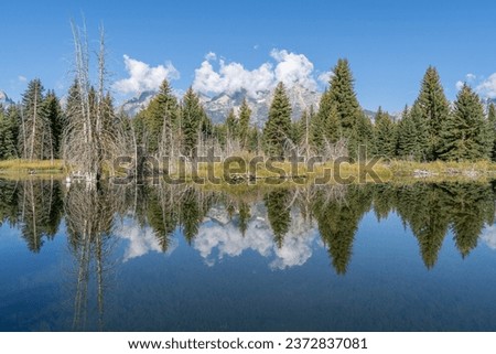 Schwabacher Landing with the Teton Mountains reflecting in the water of the Snake River in autumn