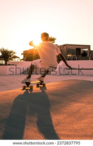 Surf skater training surfing moves near the beach at sunset. Royalty-Free Stock Photo #2372837795