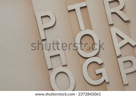 wood letters arranged on vintage paper with faded edges (the letters spell out at least in part "photography")