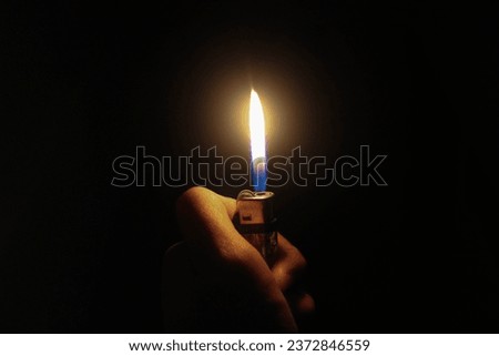 Lighters wit hand in the dark