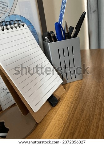 Notepad and pen holder on the table