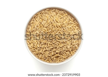 Organic Rice with Bran (Oryza sativa) or Dhaan in a white ceramic bowl. Isolated on a white background. Top View Royalty-Free Stock Photo #2372919903