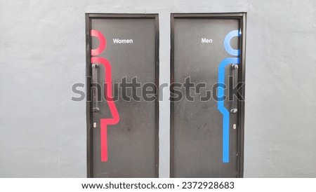 The public toilet entrance is next to each other with images of male and female symbols on each door