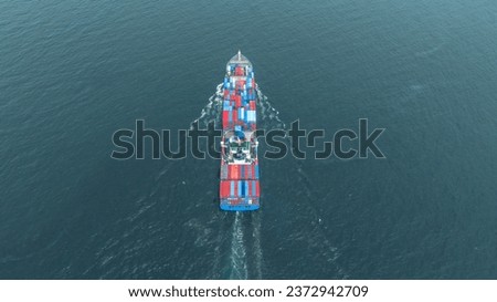 top view Cargo Container ship with contrail in the ocean ship carrying container and running for import export concept technology freight shipping by ship.	