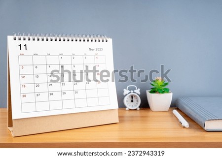 November 2023, Monthly desk calendar for 2023 year on wooden table with diary.