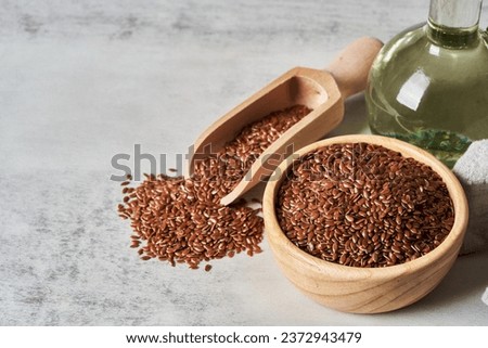 flaxseed linseed oil in wood bowl on white table background. flaxseed linseed oil on white table background. flaxseed linseed oil Royalty-Free Stock Photo #2372943479