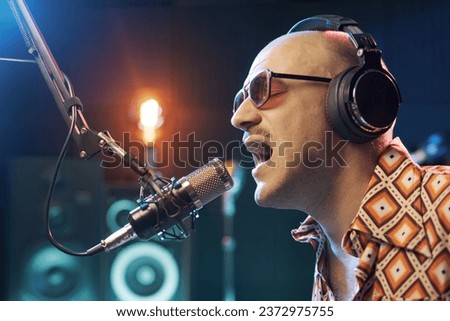 Artist singing into a microphone and recording a song in the studio