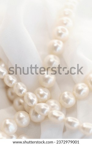 The soft glow of pearls on a white cloth paints a picture of gentle elegance. It's a nostalgic recall to authentic beauty, often overshadowed by today's digital alterations.
