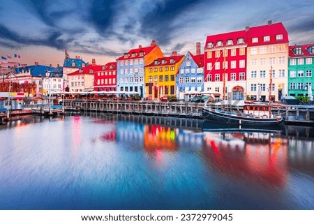 Charm of Copenhagen, Denmark at Nyhavn. Iconic canal, colorful night image and breathtaking water reflections. Royalty-Free Stock Photo #2372979045