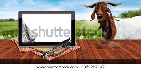 Tablet computer with blank pages on a wooden cutting board, checkered tablecloth, silver cutlery. On a wooden table with a mountain goat looking at the camera. Template for dairy products.