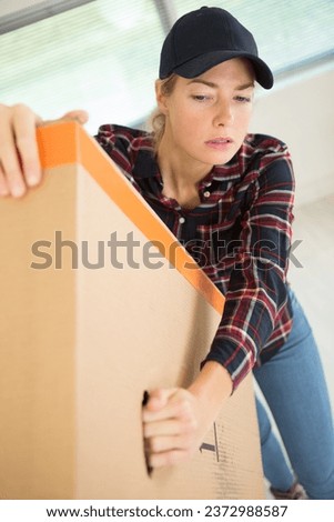 female warehouse worker carrying box
