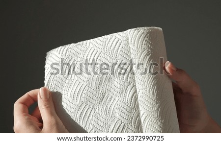 Female hands tear off piece of white paper towel from a roll. House cleaning concept. Close up, daylight. High quality photo Royalty-Free Stock Photo #2372990725