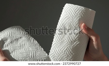 Female hands tear off piece of white paper towel from a roll. House cleaning concept. Close up, daylight. High quality photo Royalty-Free Stock Photo #2372990727