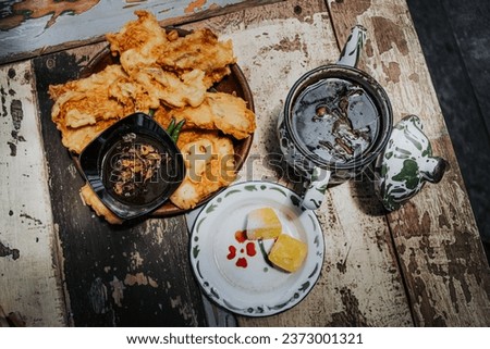 A delicious dish, fried tempeh with hot tea and sugar cubes.