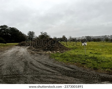 Big pile of dirt in rural area in Eastern Europe during rainy day