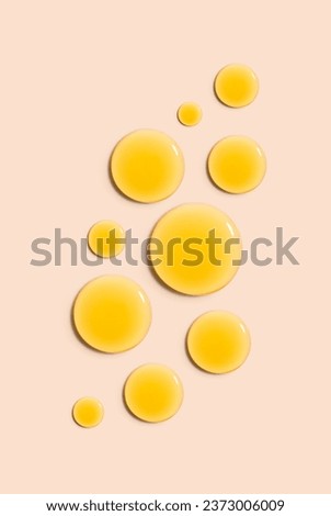 round drops gel serum on beige background Royalty-Free Stock Photo #2373006009