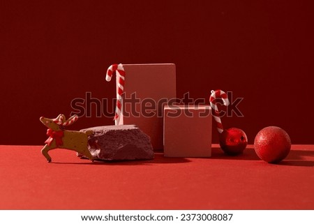 Minimalist concept for advertising with Xmas theme. On a red background, candy canes, baubles and cute reindeer decorated with podiums. Blank space for display product and design